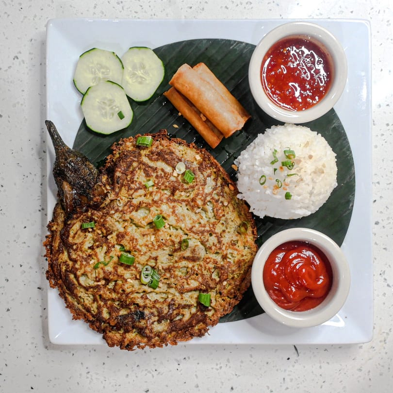 Filipino dish with fried eggplant omelet, rice, spring rolls, cucumber, and two dipping sauces.